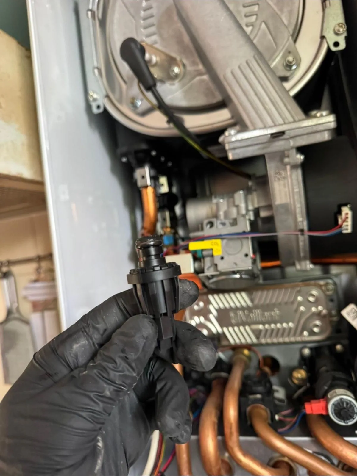 Gloved engineer removing boiler components during annual service