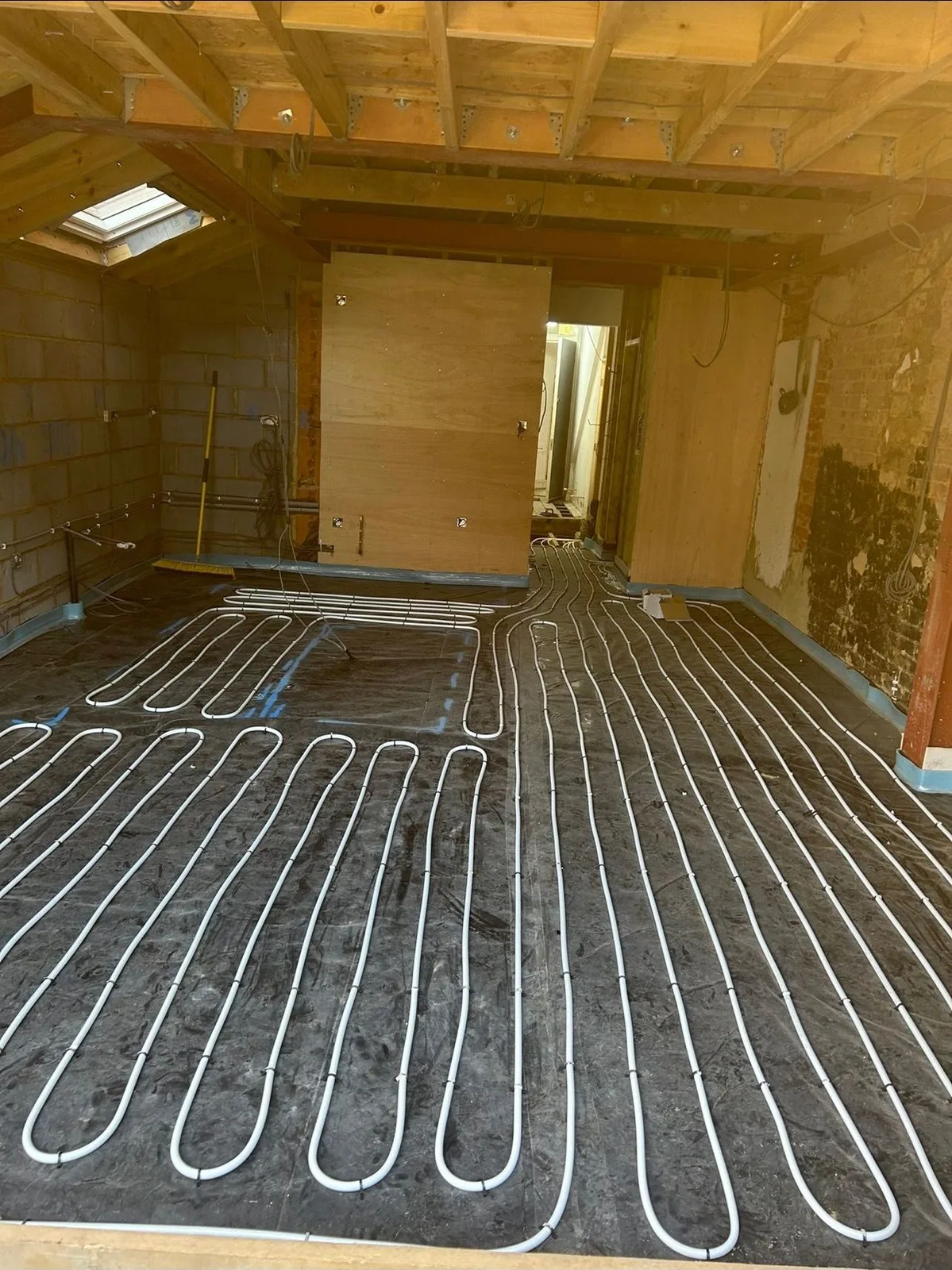 Underfloor heating pipe loops laid out across a room floor in South-East London